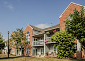 Thumbnail 4 of 31 - A red brick building with a balcony in the front. at Pointe North Apartments, Pennsylvania, 18017