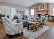 Thumbnail 15 of 31 - A living room with a brick fireplace and a grey sofa at Pointe North Apartments, Bethlehem, PA.
