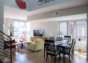 Thumbnail 1 of 16 - a living room and dining room with a table and chairs