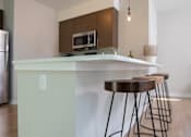 Thumbnail 9 of 16 - a kitchen with a counter top and three bar stools