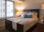 Thumbnail 11 of 19 - a bedroom with a bed and a large window
