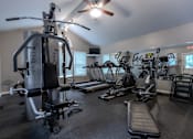 Thumbnail 11 of 26 - A gym with a variety of equipment including treadmills, elliptical machines, and a weight bench. at Meadows Apartments, Emmaus, PA, 18049