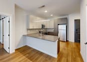 Thumbnail 13 of 35 - A modern kitchen with a wooden floor and white walls at The Standard Apartments, Pennsylvania, 18101