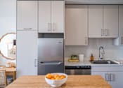 Thumbnail 3 of 58 - A kitchen with a bowl of oranges on the table.at The Teale Golden Gate in Naples, FL, 34116