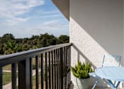 Thumbnail 5 of 58 - A balcony with a blue chair and table.at The Teale Golden Gate in Naples, FL, 34116
