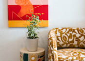 Thumbnail 6 of 58 - A painting on the wall, a plant, a table and a chair at The Teale Golden Gate in Naples, FL, 34116