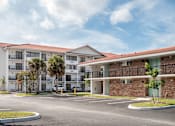 Thumbnail 9 of 58 - A large apartment complex with a parking lot in front.at The Teale Golden Gate in Naples, FL, 34116