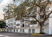 Thumbnail 10 of 58 - A large white building with balconies and a tree in front.at The Teale Golden Gate in Naples, FL, 34116