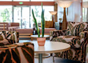 Thumbnail 45 of 58 - A living room with a couch, chairs, and a table with a potted plant on it.
