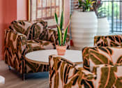 Thumbnail 46 of 58 - A living room with a couch, chairs, and a table with a plant on it.