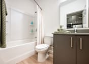 Thumbnail 12 of 58 - A white toilet sits in a bathroom next to a bathtub.