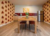 Thumbnail 38 of 58 - A dining room with a wooden table and chairs.