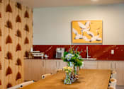 Thumbnail 44 of 58 - A dining room with a wooden table and a painting on the wall.