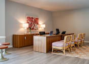 Thumbnail 53 of 58 - A room with a desk, chairs, and a painting on the wall.