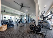 Thumbnail 42 of 58 - A gym with a variety of exercise equipment including treadmills, stationary bikes, and elliptical machines.