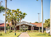 Thumbnail 18 of 58 - A building with a red roof is surrounded by palm trees.