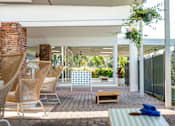 Thumbnail 26 of 58 - A patio with a white awning and a striped cushion on a chair.
