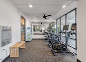 Thumbnail 13 of 21 - a gym with weights and cardio machines and a water fountain at The Teale Navy Yard, North Charleston, South Carolina