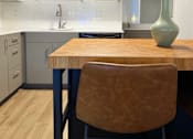Thumbnail 4 of 16 - A kitchen with a wooden table and a brown chair at The Teale Siesta Lago in Kissimmee, FL, 34746