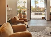 Thumbnail 9 of 16 - A living room with a row of couches and a view of the outdoors through the sliding glass doors. at The Teale Siesta Lago in Kissimmee, FL, 34746