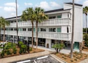 Thumbnail 1 of 11 - a large white building with palm trees in front of it at The Teale, Kissimmee, FL, 34746
