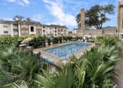 Thumbnail 39 of 40 - a swimming pool with palm trees and buildings in the background