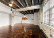 Thumbnail 18 of 40 - an empty room with a large window and wood floors
