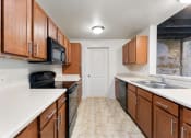Thumbnail 38 of 40 - an empty kitchen with wood cabinets and black appliances