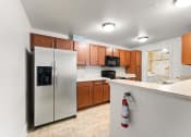 Thumbnail 37 of 40 - full kitchen with stainless steel appliances and white countertops with a bar with a bottle