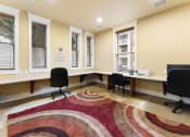 Thumbnail 34 of 40 - an office with desks and chairs and a rug