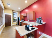 Thumbnail 33 of 40 - a kitchen with a red wall and a counter with drinks on it