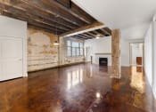 Thumbnail 12 of 40 - an empty living room with wood floors and exposed beams