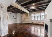 Thumbnail 13 of 40 - an empty living room with exposed brick walls and a fireplace