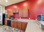 Thumbnail 32 of 40 - a kitchen with a red wall and a sink and a refrigerator