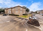 Thumbnail 4 of 40 - a large brick building at the corner of a parking lot