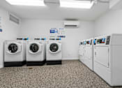 Thumbnail 13 of 16 - A row of washing machines in a laundromat at The Teale Siesta Lago in Kissimmee, FL, 34746
