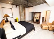 Thumbnail 34 of 38 - a bedroom with a bed and a couch and a mirror  at The Lady, Columbia, SC
