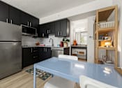 Thumbnail 17 of 20 - A kitchen with a blue table and white chairs.