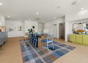 Thumbnail 10 of 20 - A dining room with a blue rug and chairs.