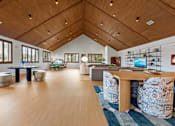 Thumbnail 9 of 20 - A room with a wooden floor and ceiling, furnished with a table and chairs.