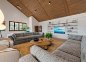 Thumbnail 1 of 20 - A living room with a grey couch and a wooden coffee table.