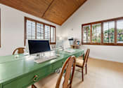 Thumbnail 6 of 20 - A green desk with a computer on it in a room with wooden ceiling and windows.