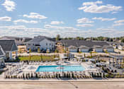 Thumbnail 25 of 31 - A large swimming pool surrounded by a grassy area and a few trees.