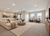Thumbnail 15 of 15 - A living room with a large sectional sofa and a coffee table.