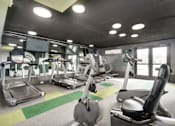 Thumbnail 16 of 25 - A gym with treadmills, exercise bikes and other equipment.