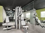 Thumbnail 17 of 25 - A gym with a variety of equipment including a leg press machine.