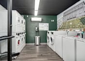 Thumbnail 18 of 25 - A laundromat with a green wall and a picture of a football stadium.