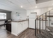 Thumbnail 2 of 25 - A kitchen with white cabinets and a black railing.