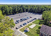 Thumbnail 22 of 25 - A parking lot with cars and a building in the background.