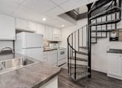 Thumbnail 1 of 25 - A kitchen with a spiral staircase in the middle.